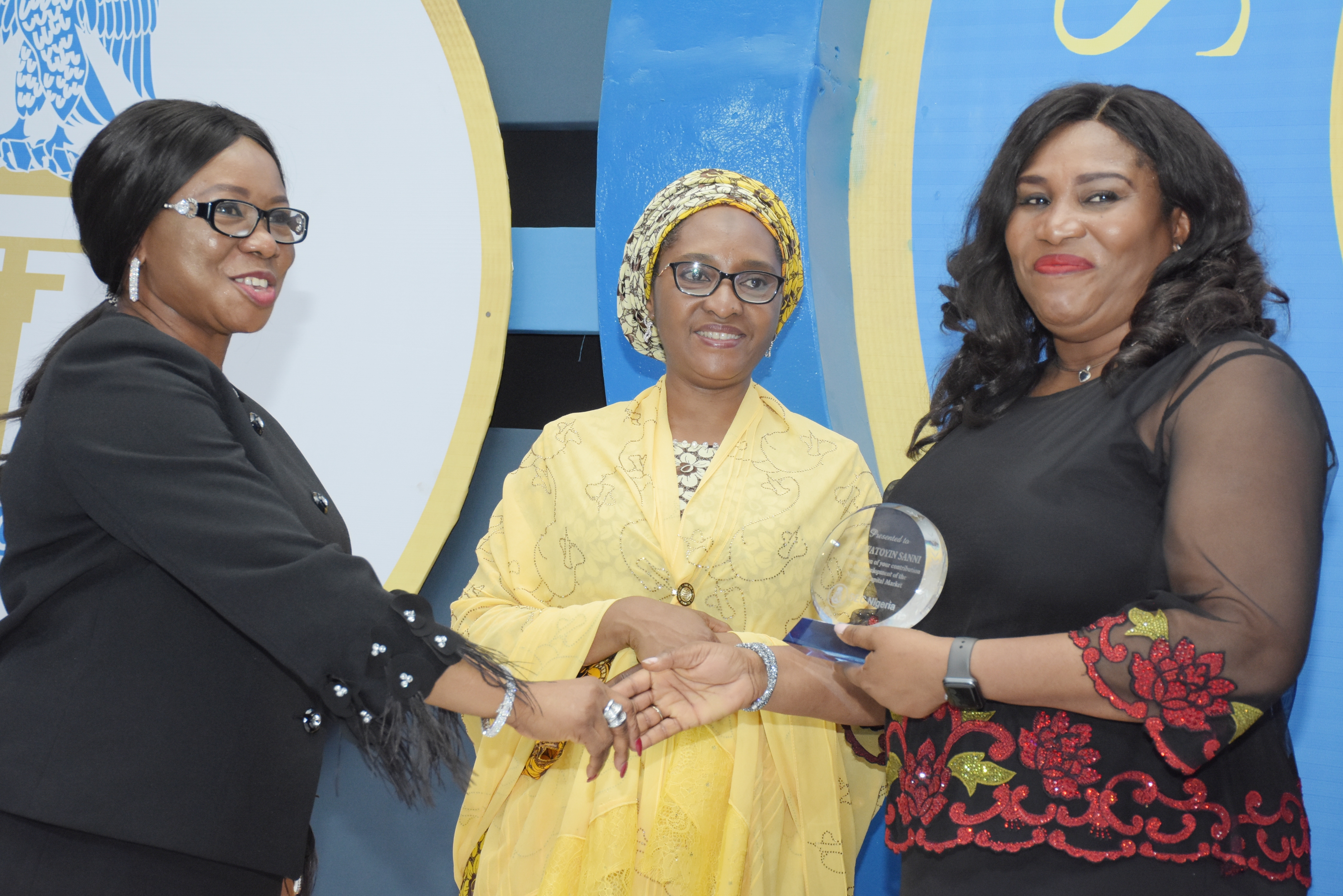 L-R:  Ag. Director-General, Securities and Exchange Commission and the Ms Mary Uduk, Minister of Finance, Mrs Zainab Ahmed present an award plaque to Financial Literacy committee Chairman, Mrs Oluwatoyin Sanni  at the SEC Awards Night in Lagos on Tuesday, March 19, 2019.