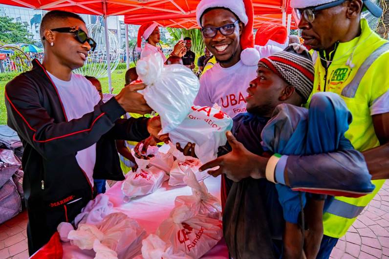 UBA's Brand Ambassador, Wizkid, handing over food items and other goodies to the helpless and under-privileged at the Food Bank organised by UBA Foundation at the Foundation’s Garden and Roundabout in Marina, Lagos on Friday